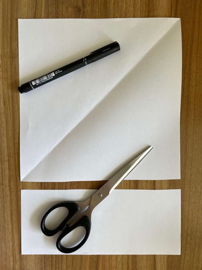 A rectangular piece of paper with the bottom cut off to make a square piece of paper.