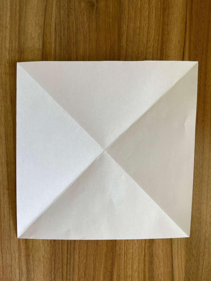 A square piece of paper with diagonal creases. 