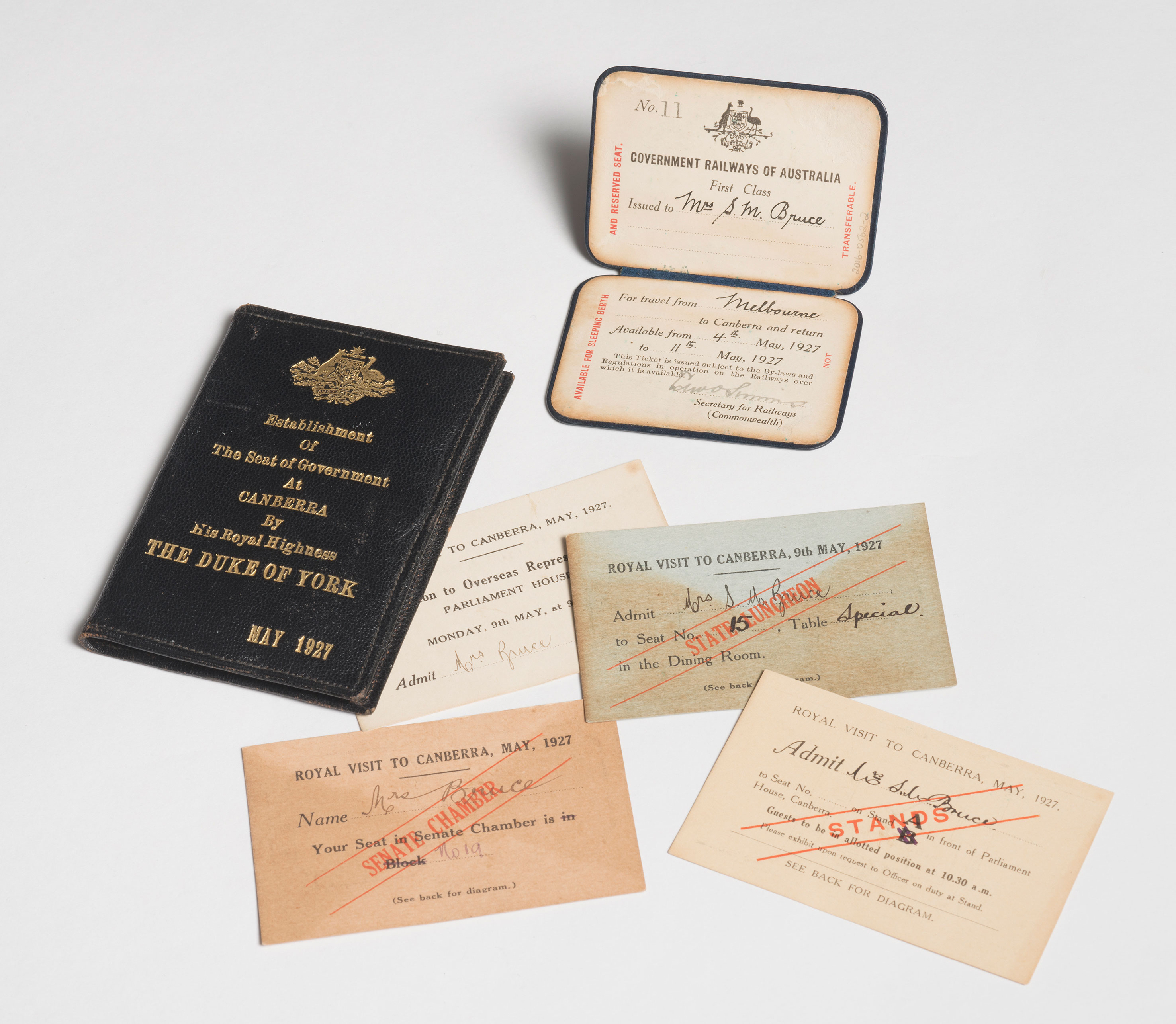 A selection of rail tickets with hand written cursive text and a blue leather wallet. 