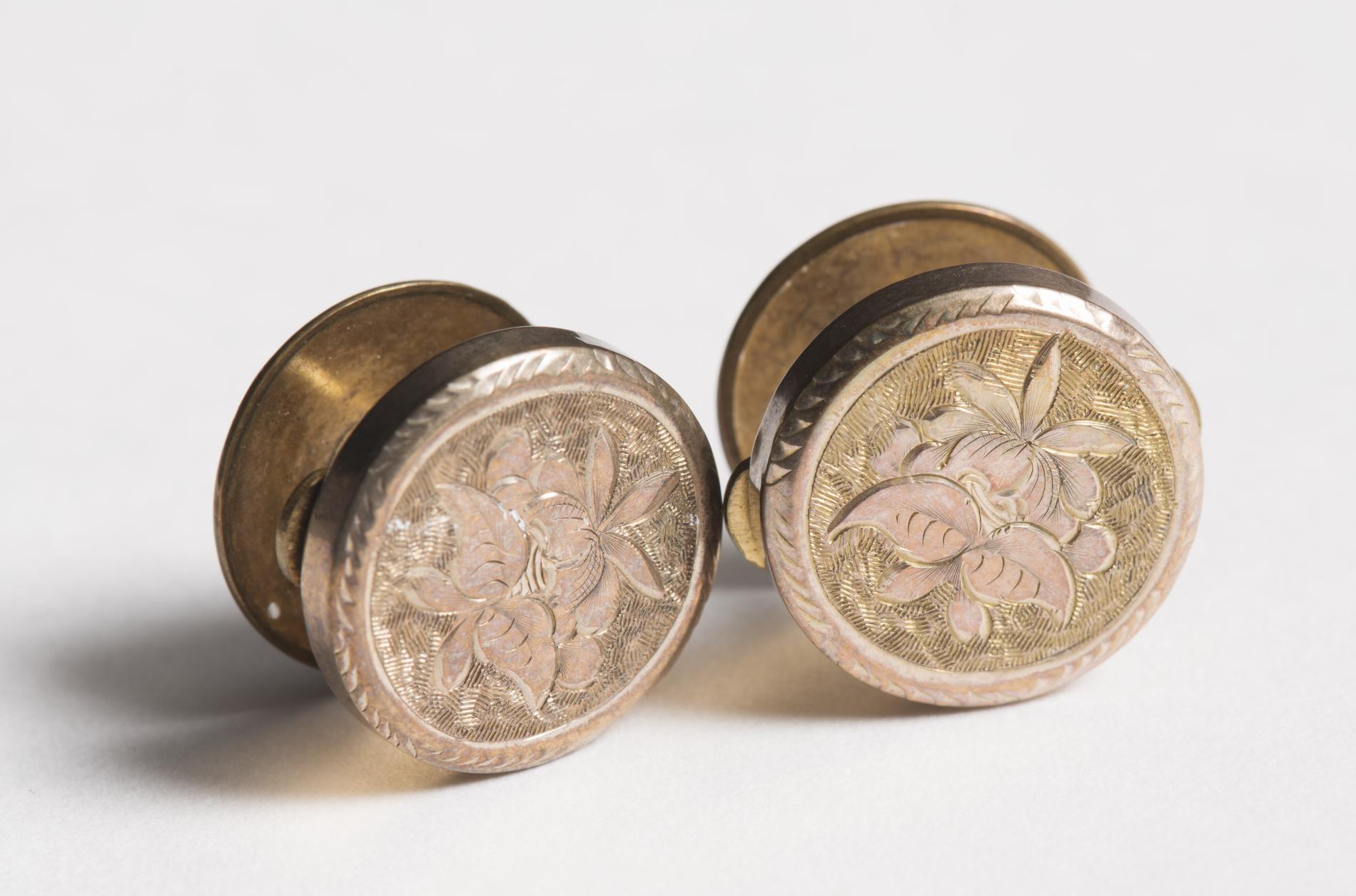 Photograph of two brass coloured cufflinks