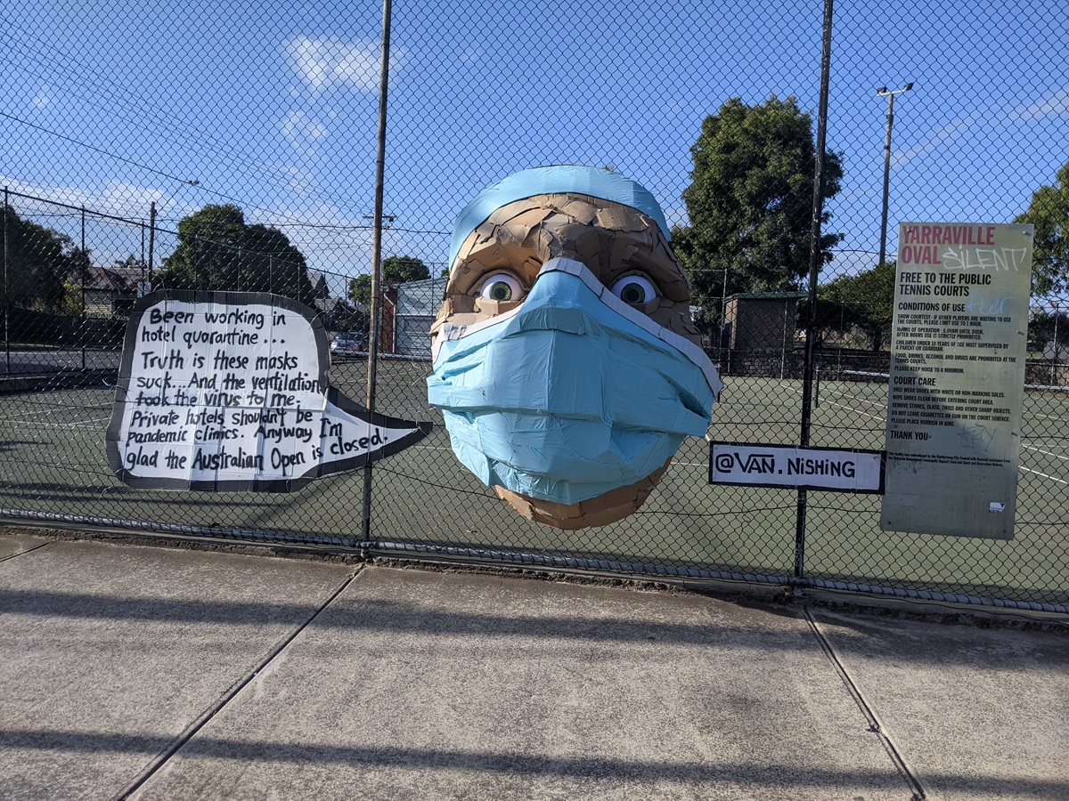 Bust of a hotel quarantine worker is attached to a tennis court. They say how they're glad the Australian Open is closed. 