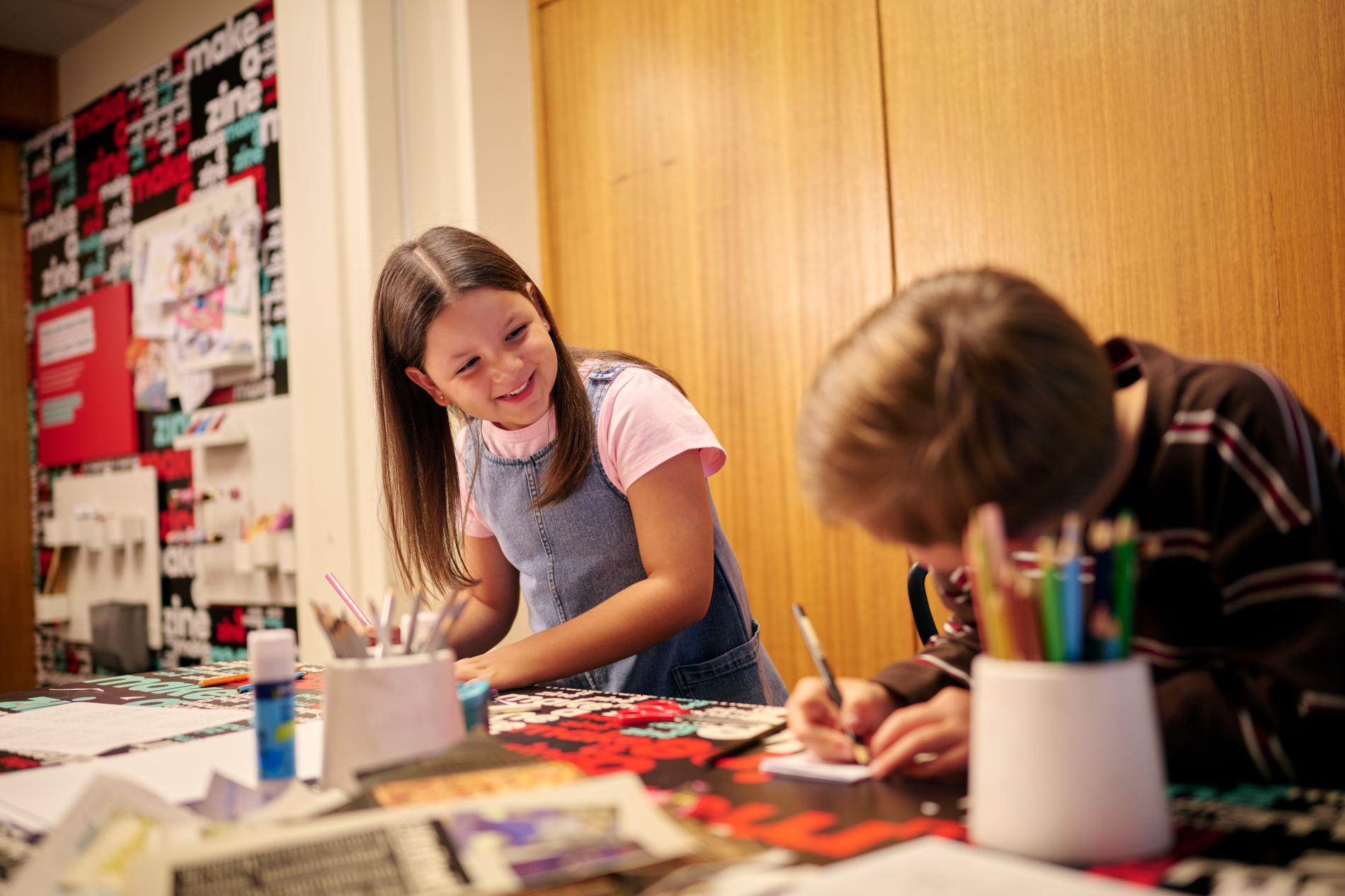 Two children creating their own zines in the Zine Lounge at the Museum of Australian Democracy at Old Parliament House.