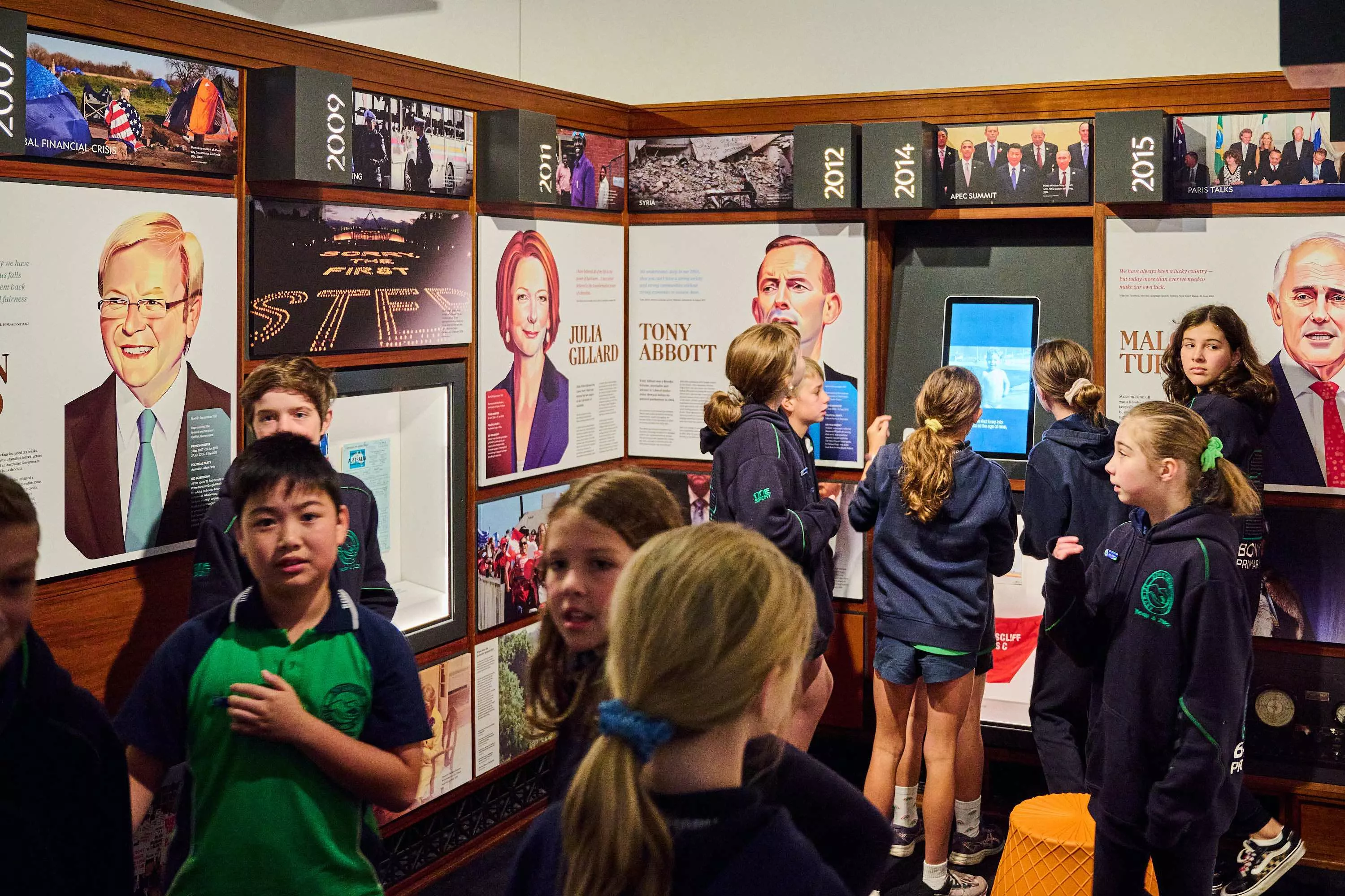 Primary school students look around the exhibits in the Democracy DNA exhibition featuring panels of prime ministers including Kevin Rudd and Julia Gillard. 