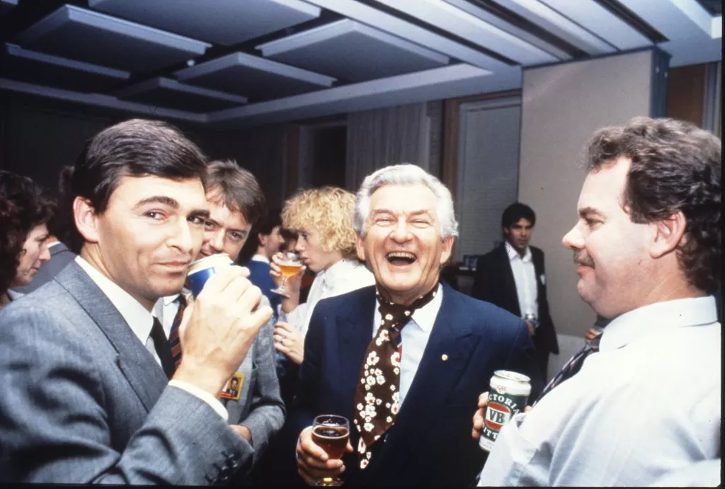 MP John Brumby (left) and Prime Minister Bob Hawke (centre) join colleagues in the Senate Committee Room for a beer and a laugh.