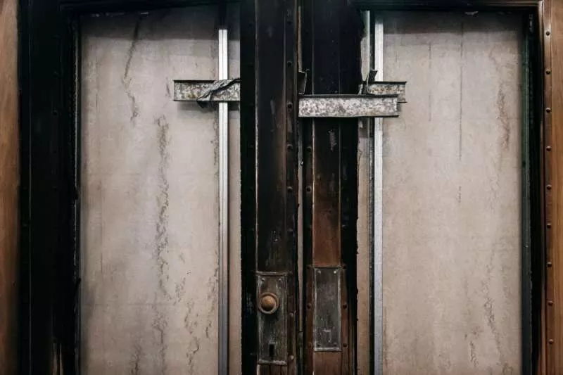 The front doors of Old Parliament House, burnt and boarded shut.