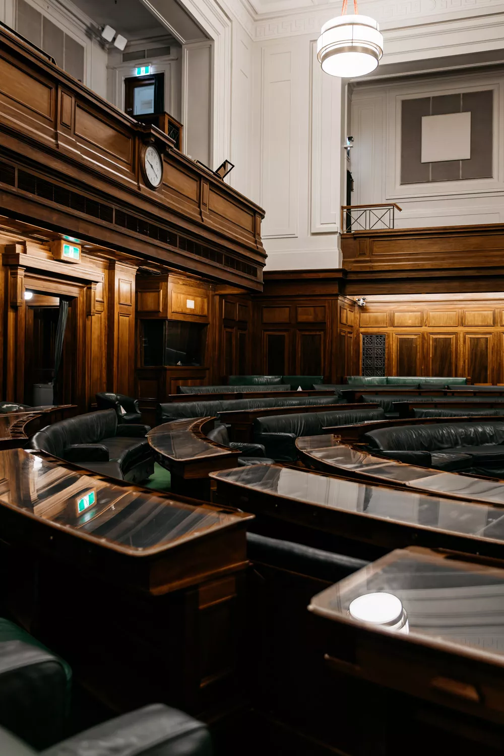 A row of desks in a U shape with green leather. 