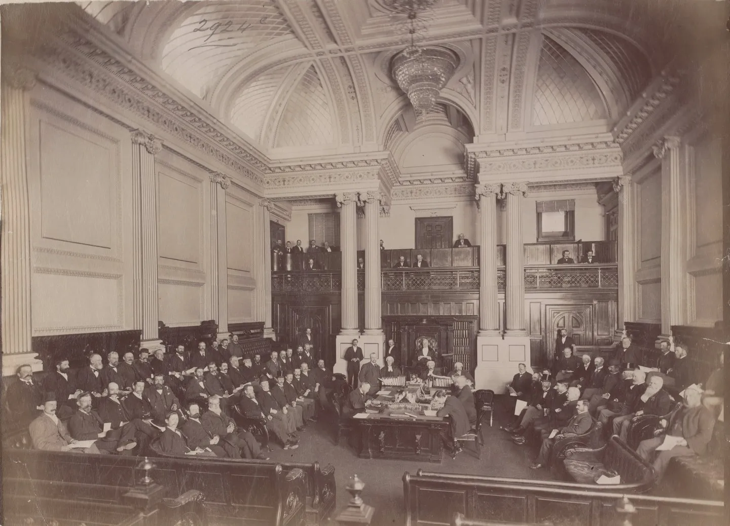 Black and white photograph of the Victorian Legislative Assembly with its members seated.