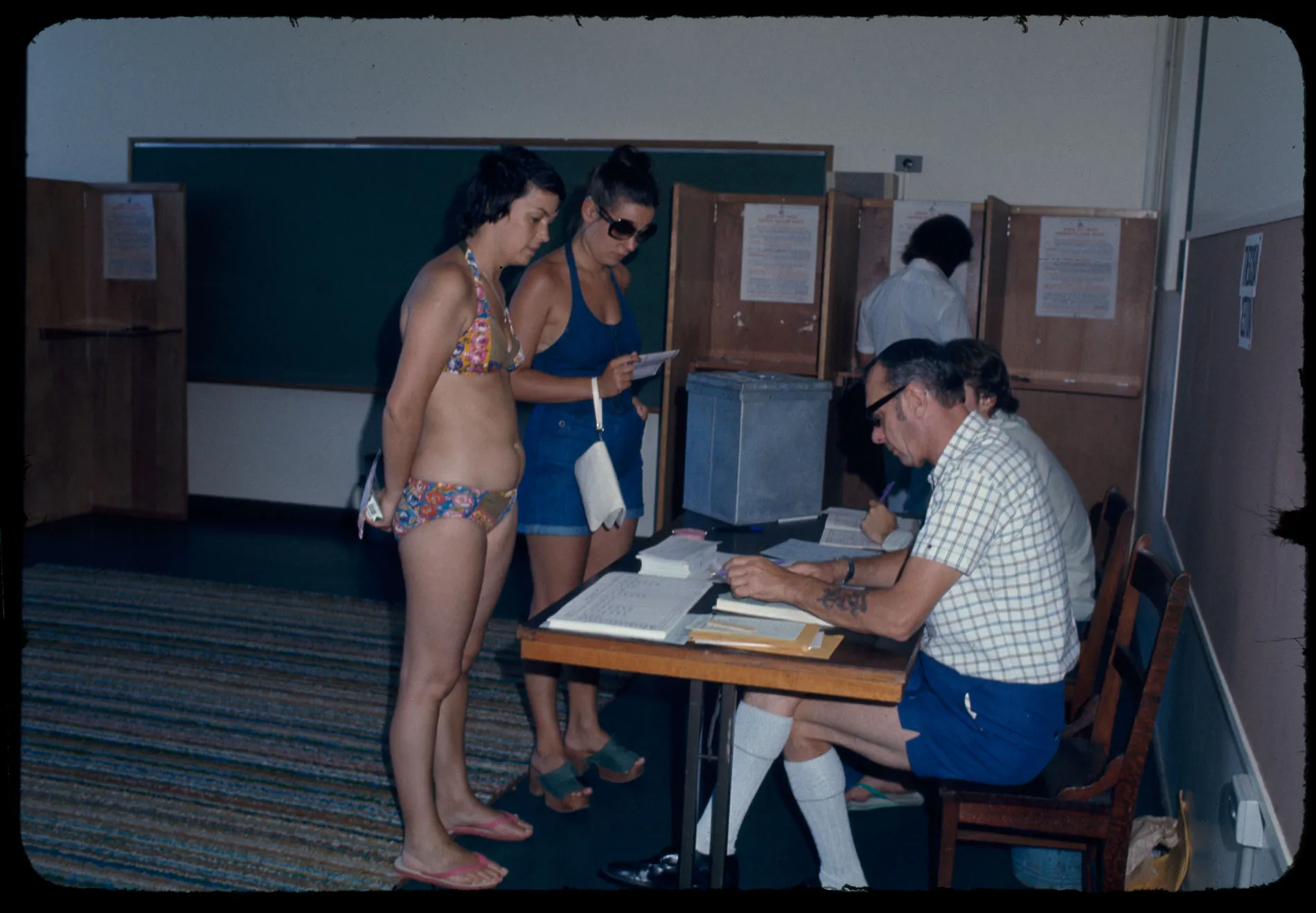 Two women in swimwear vote at a polling station in the 1975 election.