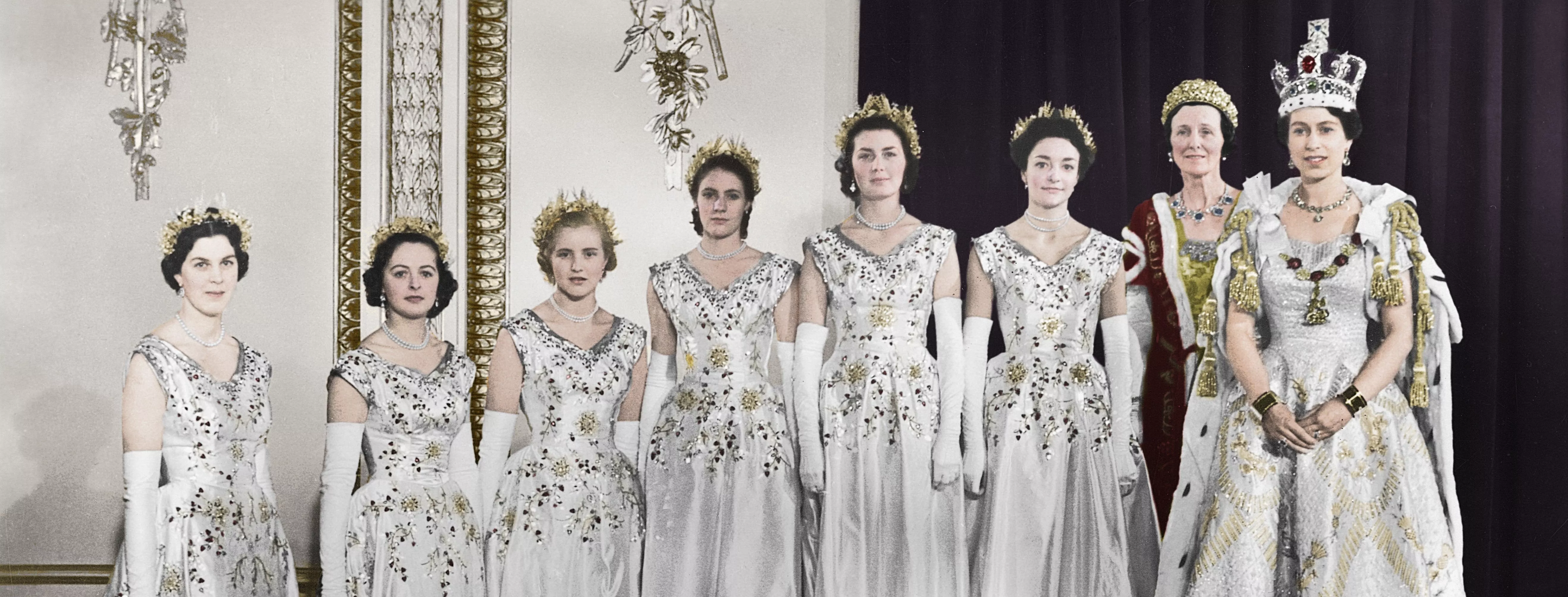 A colourised photograph of Queen Elizabeth, wearing her coronation gown, accompanied by seven maids of honour.