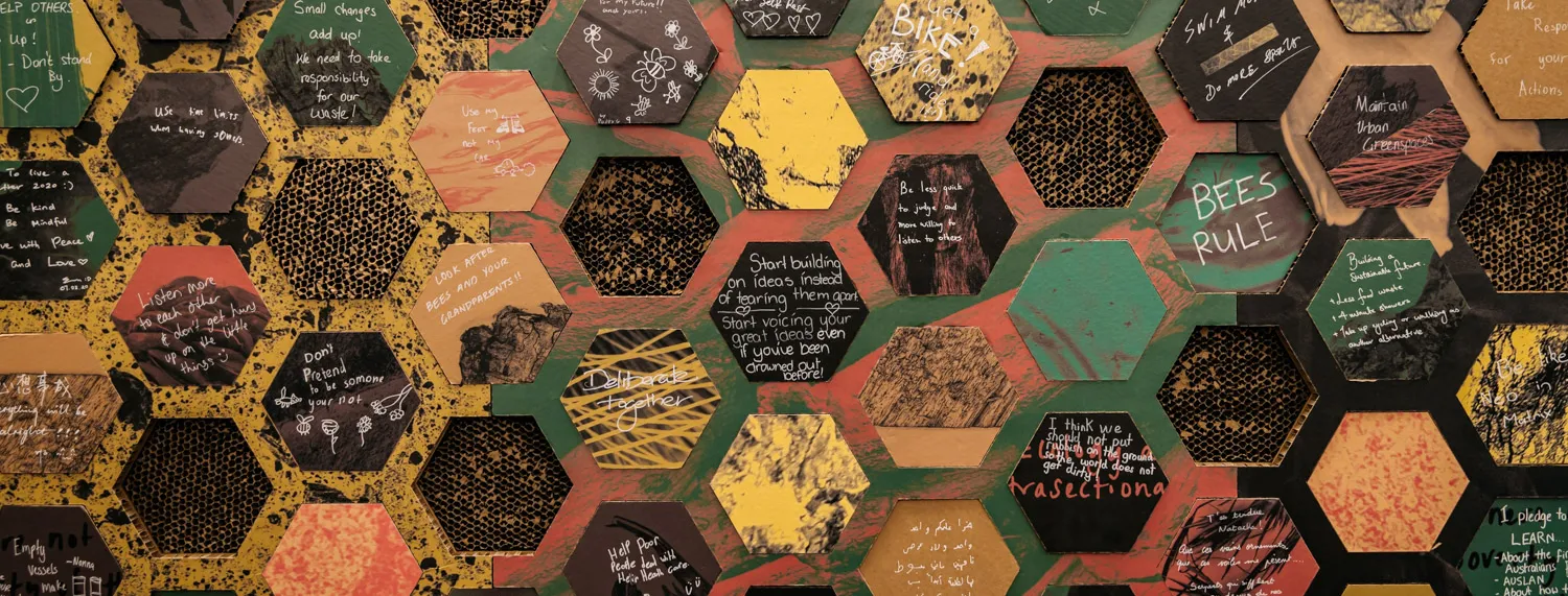 A series of cardboard hexagons that fit into a wall display. There are statements written on each honeycomb with words such as 'respect diversity of culture'.
