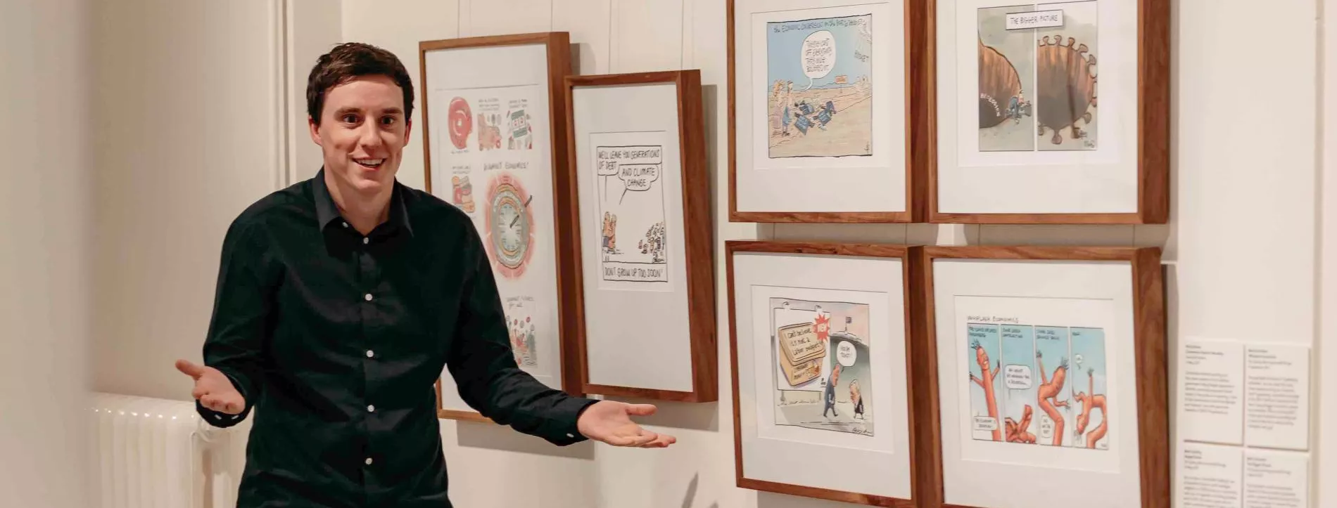 A MoAD educator stands in front of a wall of political cartoons. 