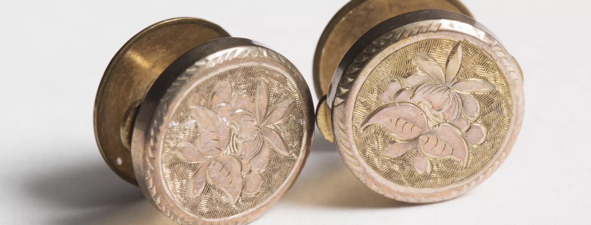 Photograph of two brass coloured cufflinks