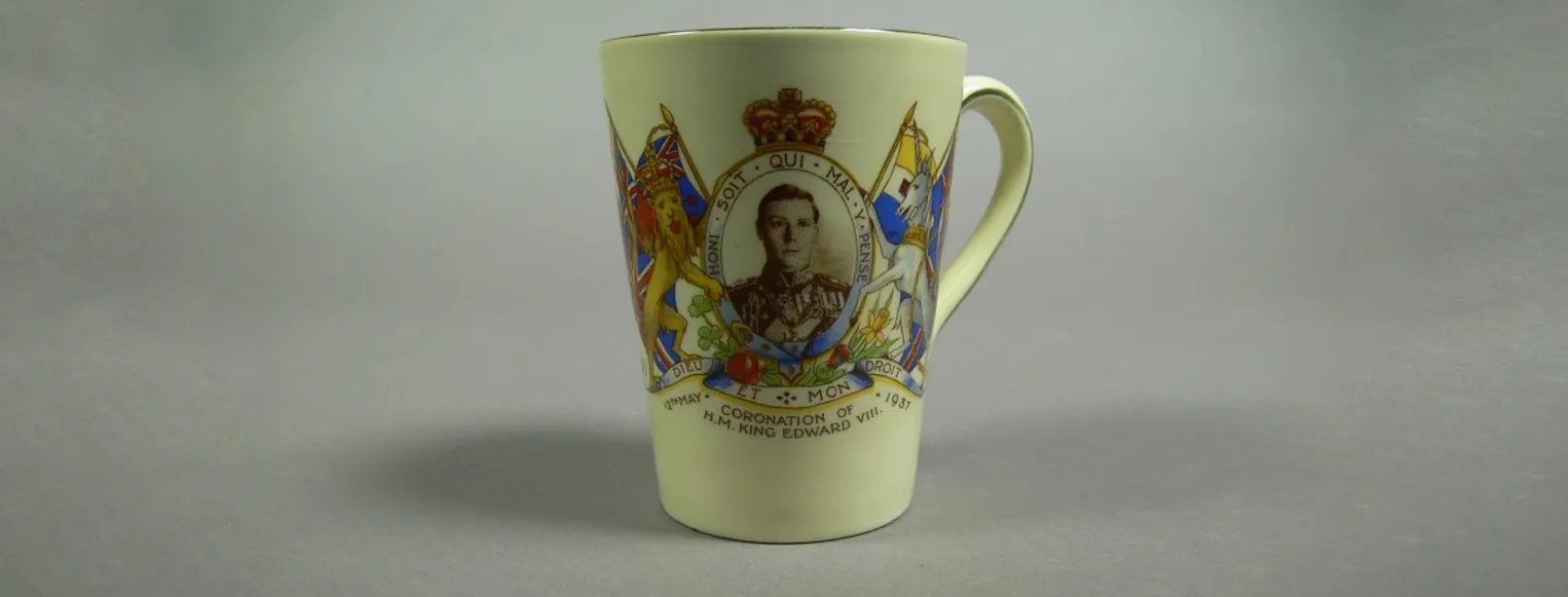 A ceramic mug featuring a portrait of Prince Edward, framed with the British coat of arms, with the words 'Coronation of H.M. King Edward VIII' and '12th May 1937'.