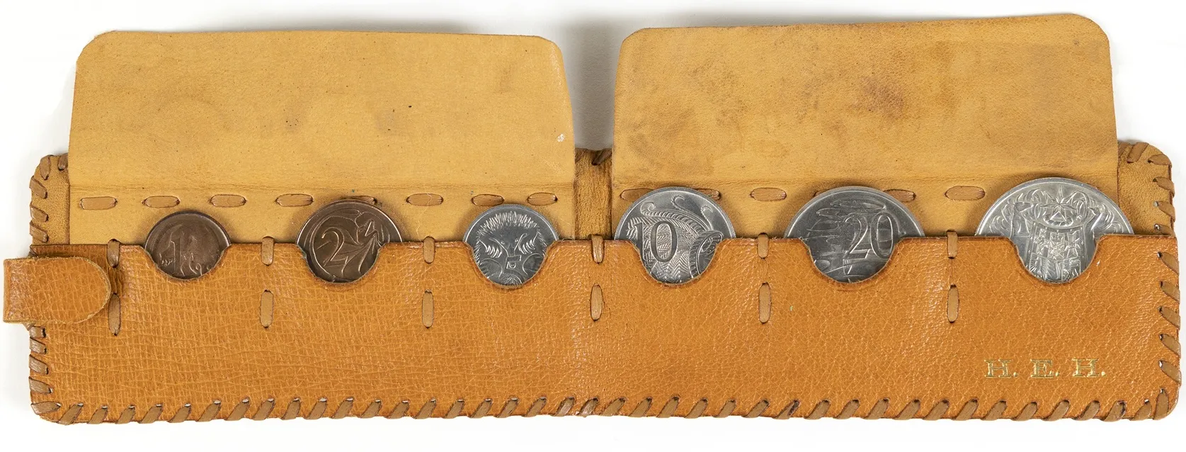 A leather pouch embossed with the letters H. E.H and holding a 1-cent, 2-cent, 5-cent, 10-cent, 20-cent and 50-cent coins