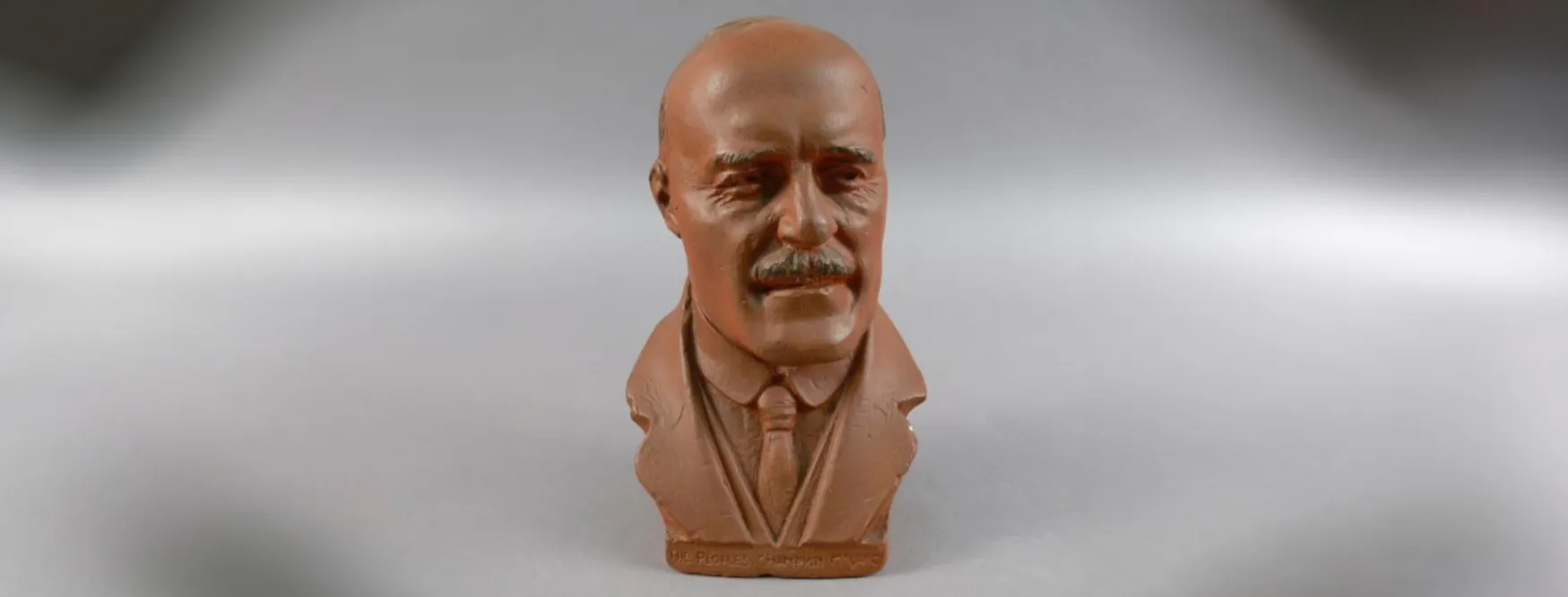 A terracotta clay bust of Jack Lang, wearing a tie and jacket lapels.