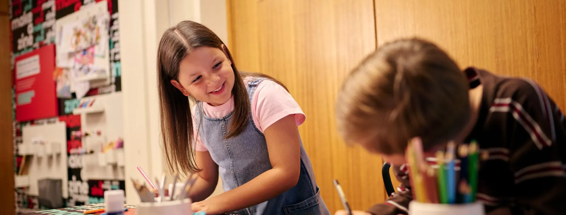 Two children creating their own zines in the Zine Lounge at the Museum of Australian Democracy at Old Parliament House.