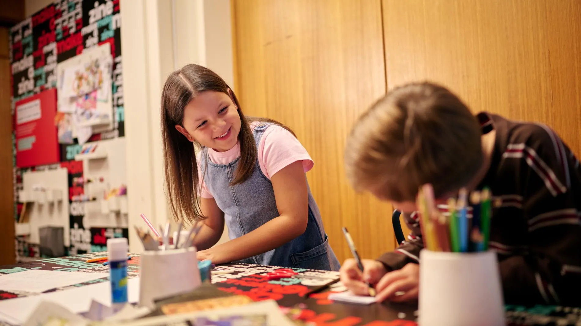 Two children creating their own zines in the Zine Lounge at the Museum of Australian Democracy at Old Parliament House.