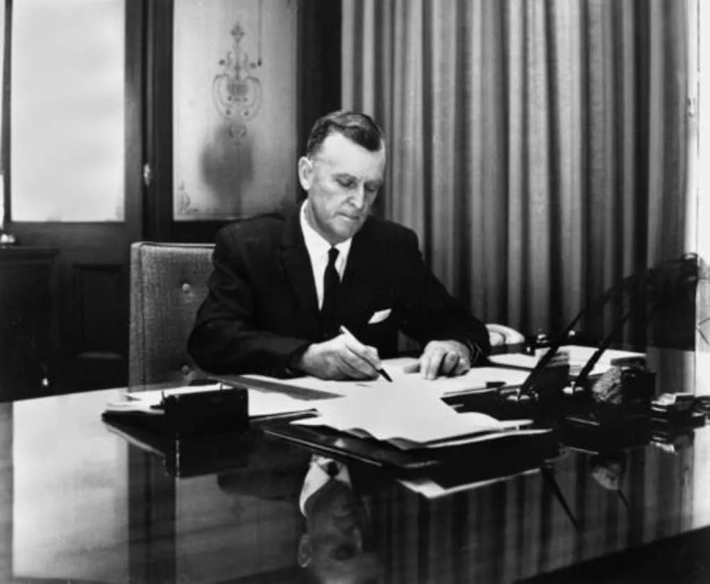 Photograph of Joh Bjelke-Petersen sitting at a desk writing