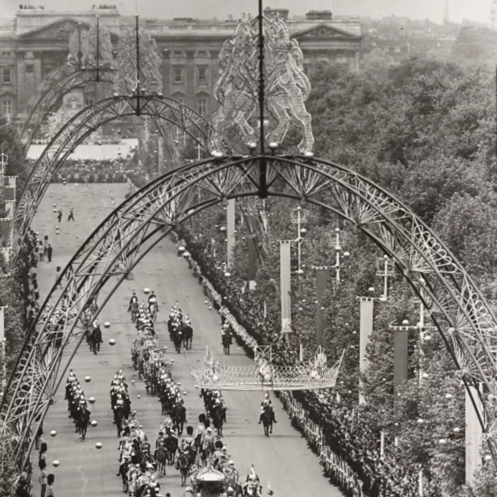 Queen Elizabeth II’s coronation procession proceeds down the Mall from Buckingham Palace underneath magnificent ornamental arches. Image: Royal Collection Trust Queen Elizabeth II’s coronation procession proceeds down the Mall from Buckingham Palace underneath magnificent ornamental arches.