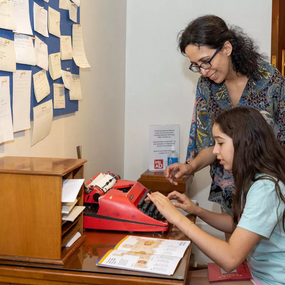 One visitor sat trying out a red typewriter while another watches