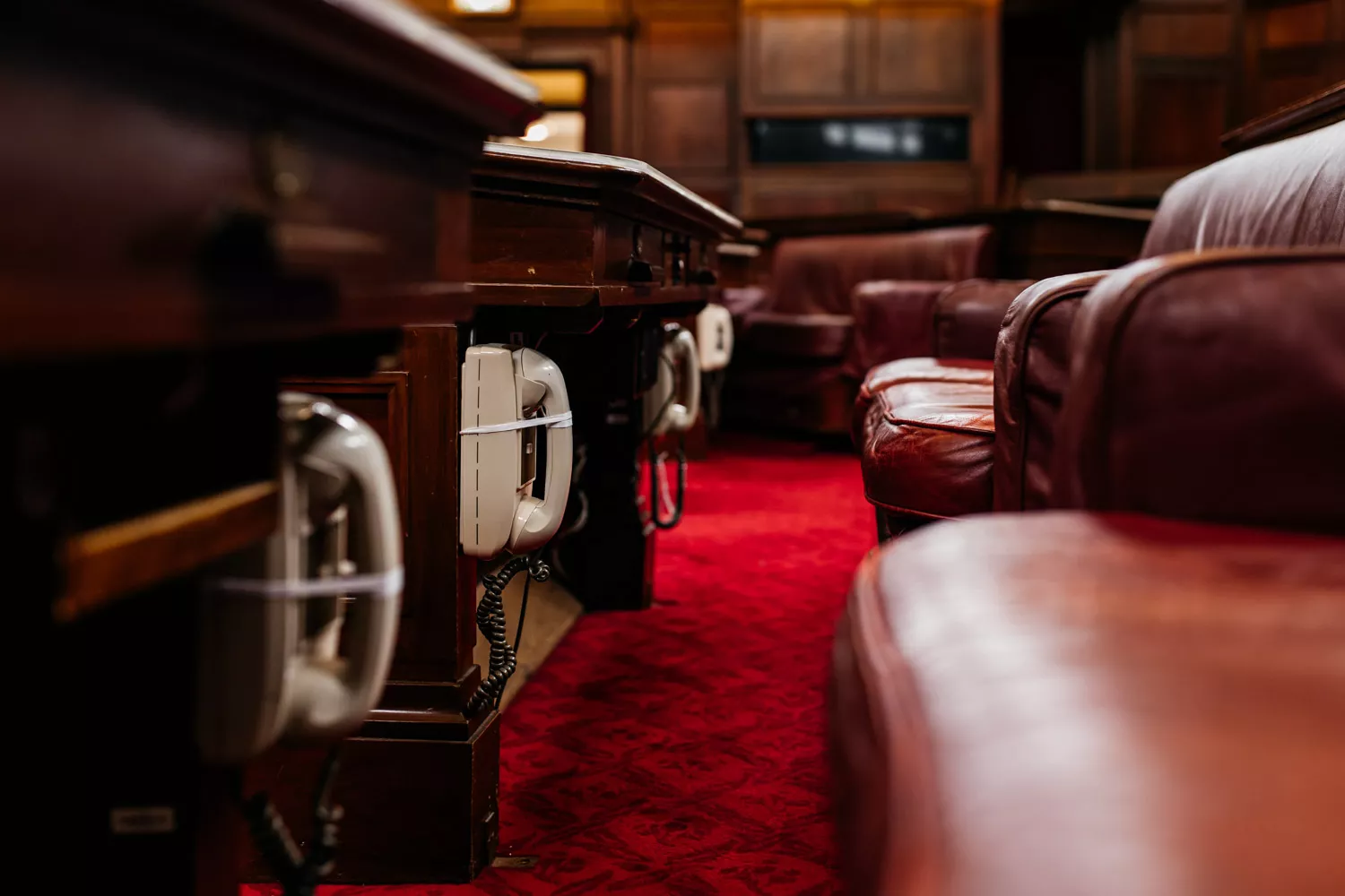 A close up of old fashioned phones underneath desks in the Senate Chamber. 