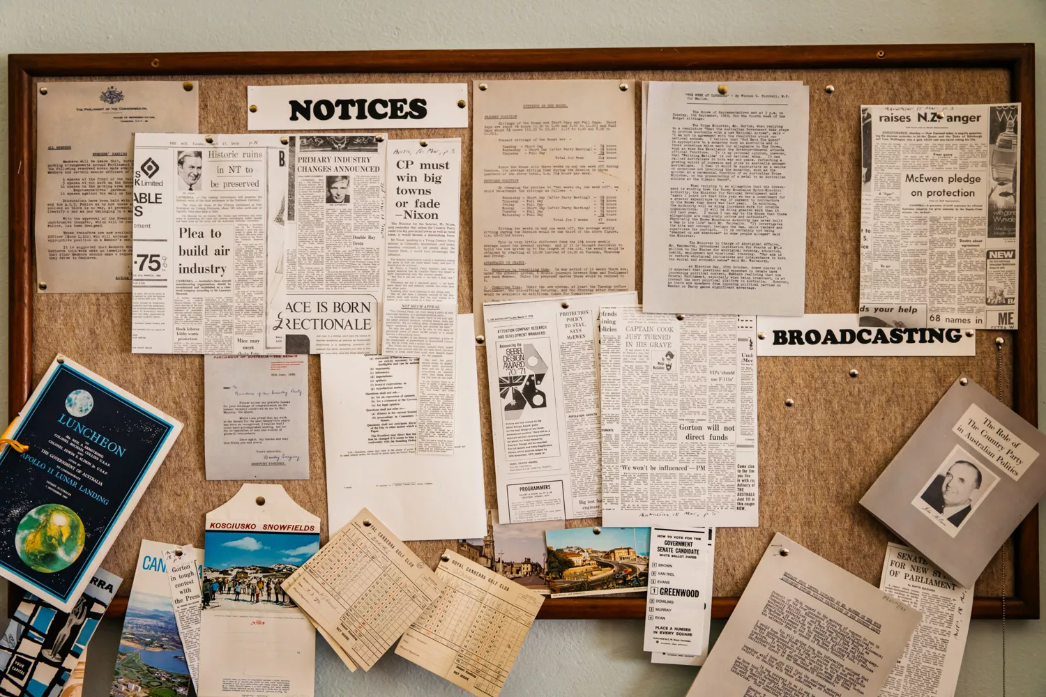 A pinboard covered with cutouts from newspapers from 1985, a postcard from the Kosciusko snowfields and a booklet with a black and white photo and the title 'the role of the Country Party in Australian politics.'