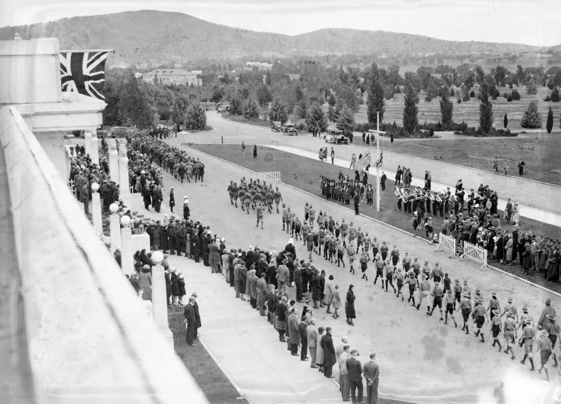 Boy scouts marching in front of Old Parliament House with audience and brass band playing, Anzac Day 1933.